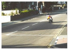 A rider screams across the famous quarterbridge during the time trials, inches away from spectators quaffing their brews.